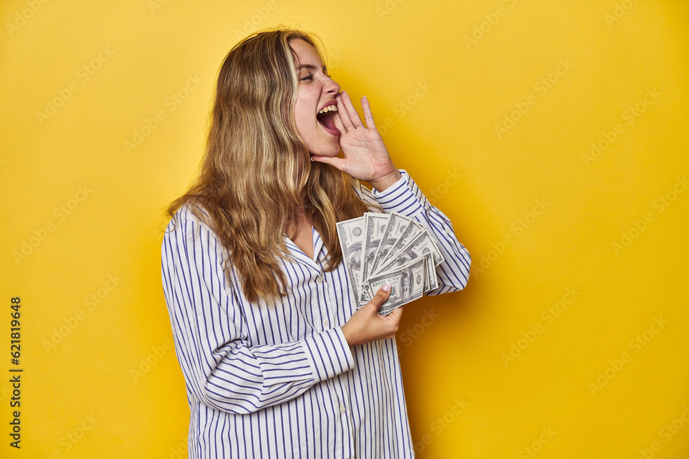 Young Caucasian Woman Holding Cash shouting and holding palm near opened mouth. Young Caucasian Woman Holding Cash shouting and holding palm near opened mouth.