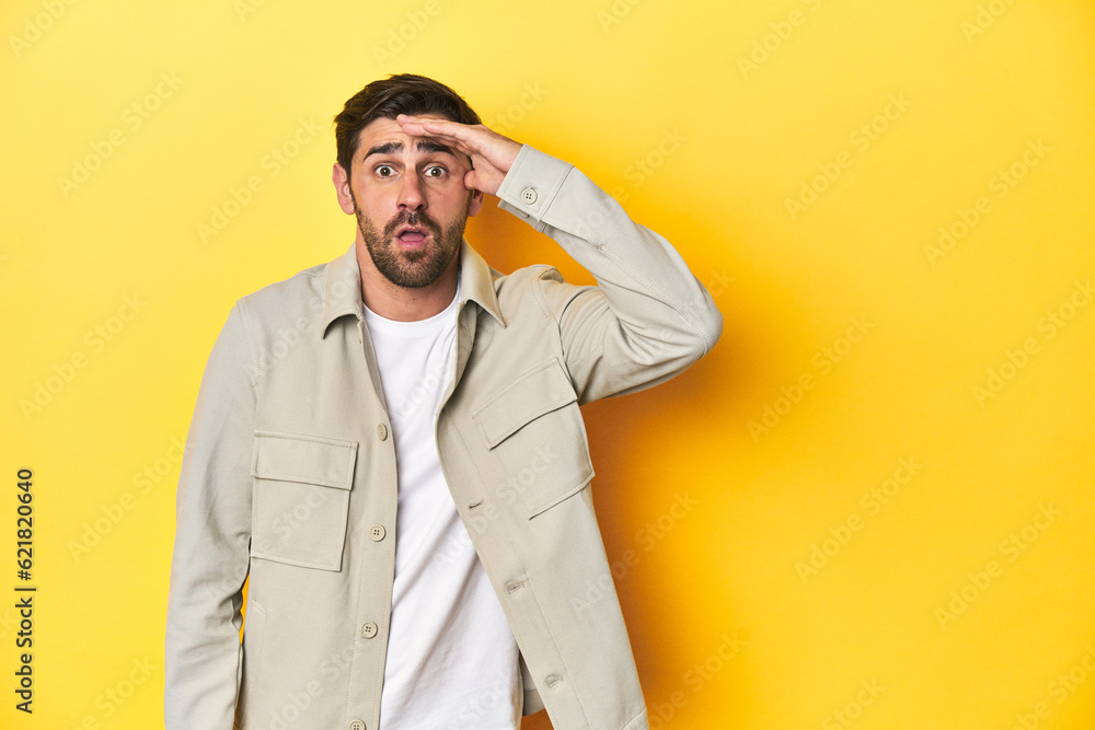 Caucasian man in grey shirt, studio shot on yellow shouts loud, keeps eyes opened and hands tense. Caucasian man in grey shirt, studio shot on yellow shouts loud, keeps eyes opened and hands tense.