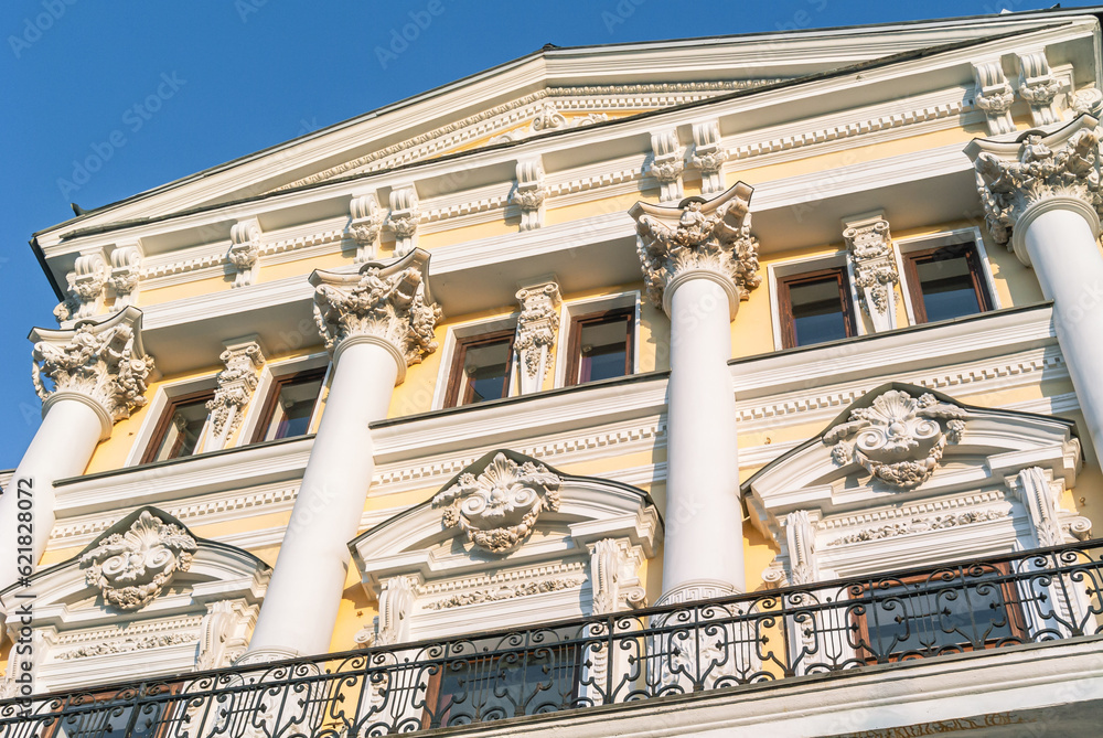 Obraz premium Decoration of stucco on the facade of an old building of the 19th century. The facade of a mansion built in the 19th century. Ancient architecture with stucco on the facade.