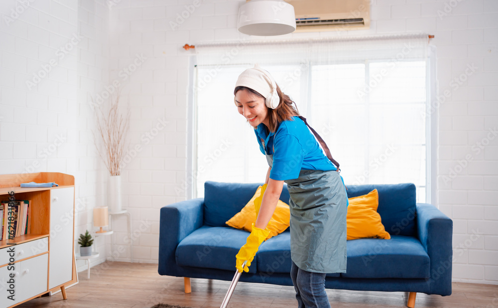 Fototapeta premium Happy Housework or house keeping service female singing and cleaning dust in house, cleaning agency small business. professional equipment cleaning old home.