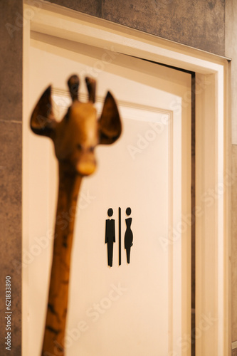 Foto Une girafe devant un panneau indiquant les toilettes