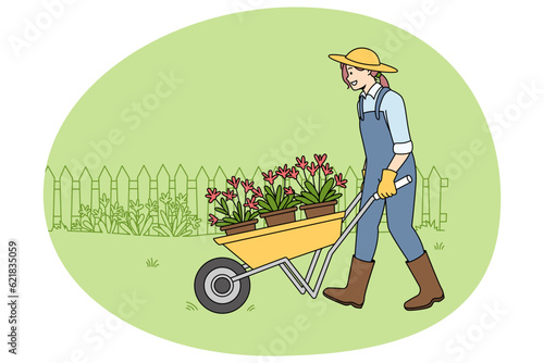 Happy woman gardener in uniform with wheel cart doing outdoor works. Smiling female gardening planting flowers outside. Environment and hobby concept. Vector illustration.