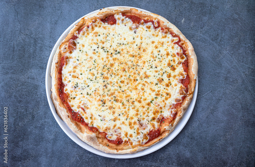 Italian pizza Margherita with cheese and tomato sauce on the rustic table.Top viewv Italian pizza Margherita with cheese and tomato sauce on the rustic table.Top viewv