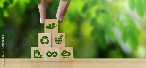 ESG Concepts in Environment, Society and Governance Sustainable Organization Development Hand holding a wooden block with green ESG icon on green nature background. copy space