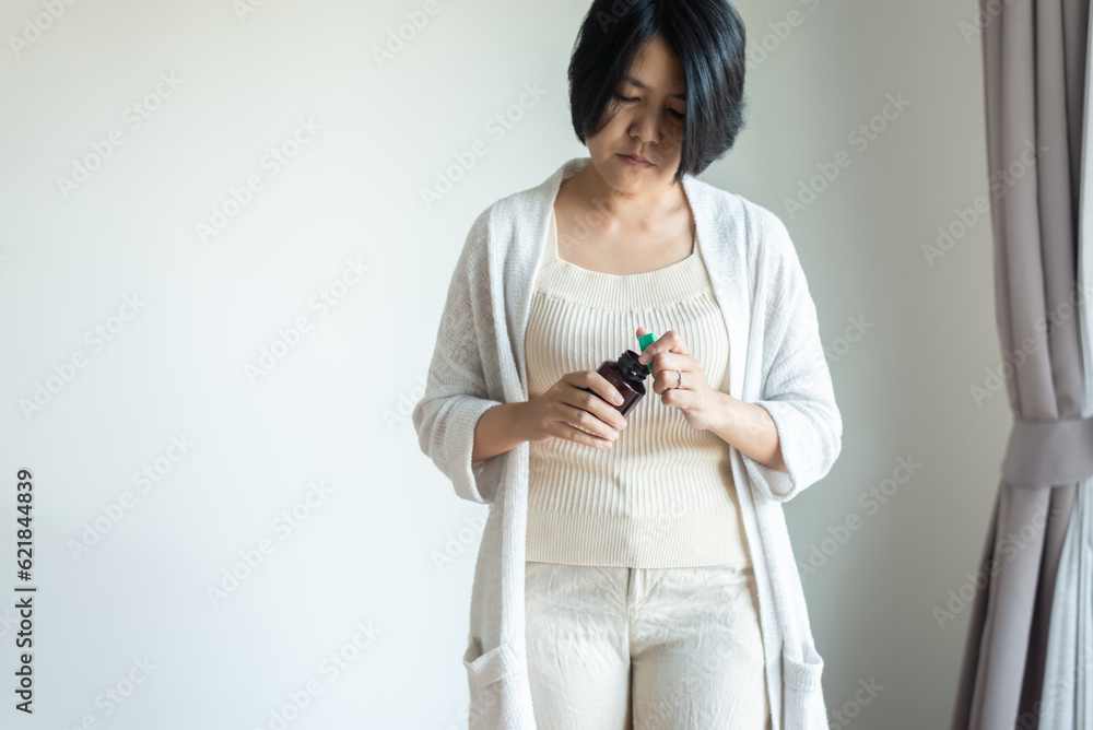 Woman hands opening a glass pills bottle,Women hand holding a medicine Woman hands opening a glass pills bottle,Women hand holding a medicine