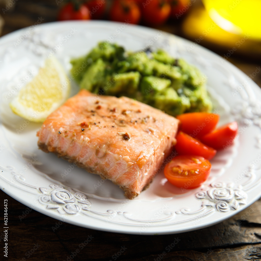 Healthy baked salmon fillet with mashed avocado
