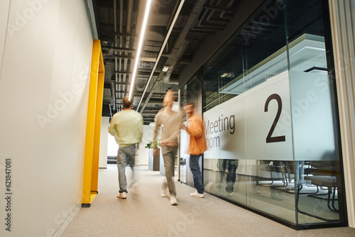 Принти на полотні motion blur of energetic and ambitious businessmen walking in corridor of modern