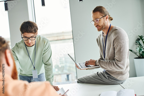 Fotografie architectural designer in eyeglasses and casual clothes sitting on work desk, ty