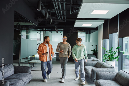 Vászonkép optimistic businessmen in stylish casual clothes, with paper cup, smartphone and