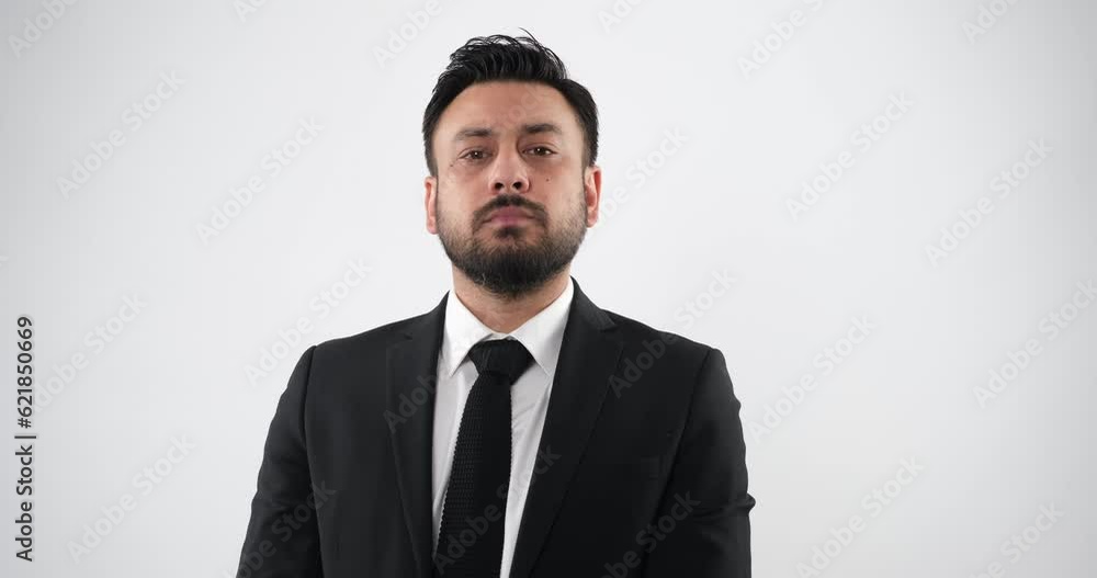The businessman in a studio setting, through close-up shots, looks at the camera and makes gestures and facial expressions indicating disapproval, conveying a non-verbal 'no' response The businessman in a studio setting, through close-up shots, looks at the camera and makes gestures and facial expressions indicating disapproval, conveying a non-verbal 'no' response