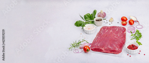 Dry aged Bavette steak with traditional spices and herbs. Fresh raw meat cut, light stone background photo