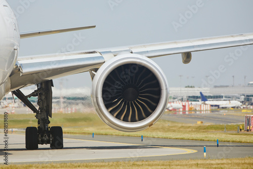 Hot air behind jet engine of plane at airport. Airplane is taxiing to runway for take off during sunny summer day..