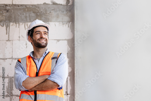 Fototapeta engineer handsome man or architect looking construction with white safety helmet in construction site