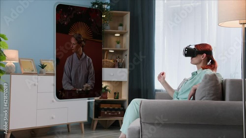 modern technology,  young woman in VR glasses looks at photos from a smartphone gallery while sitting on a sofa in a room photo