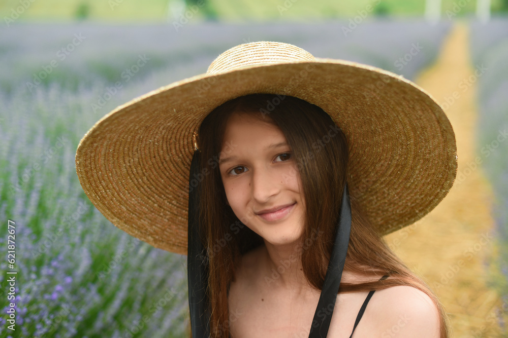 portrait of a woman in a hat. Beautiful girl with long hair smiling. girl in lavender field