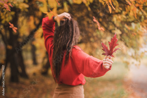 Portrait of a yPortrait of a young woman in a beige coat and hat in the park in autumn with leaves close-up. selected focusoung woman in a beige coat and hat in the park in autumn with leaves close-up photo
