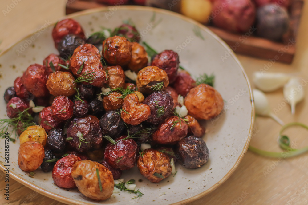 young colored potatoes baked whole in the oven on a plate close-up, appetizing potatoes young colored potatoes baked whole in the oven on a plate close-up, appetizing potatoes