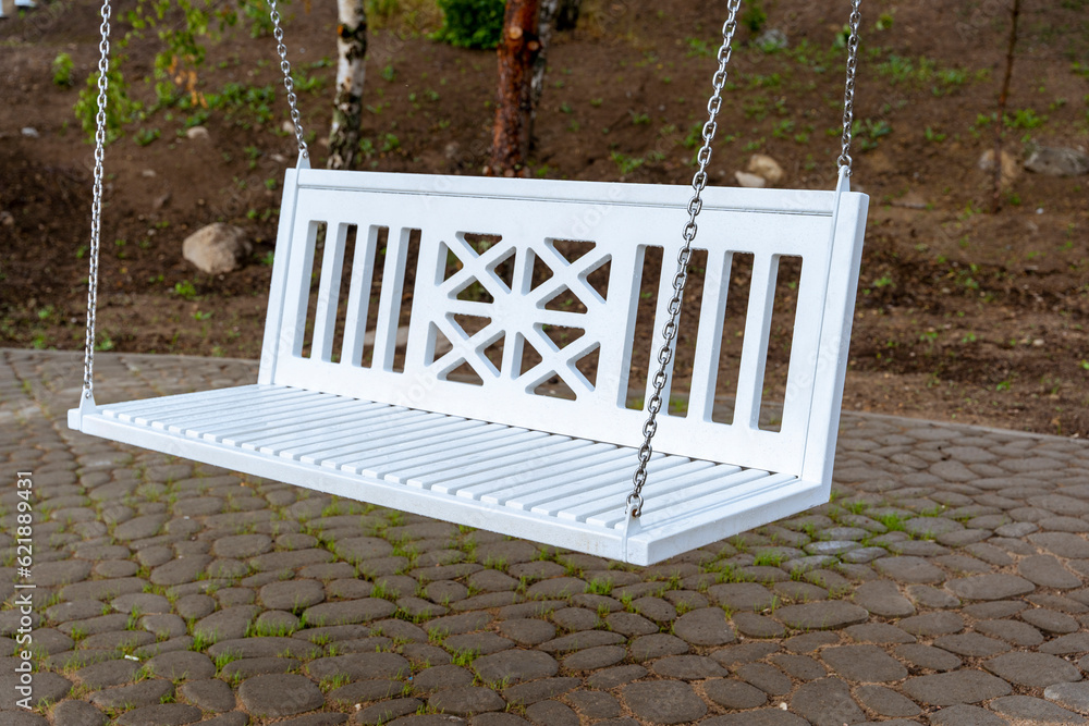 white bench-swing on chains in the park - obrazy, fototapety, plakaty 