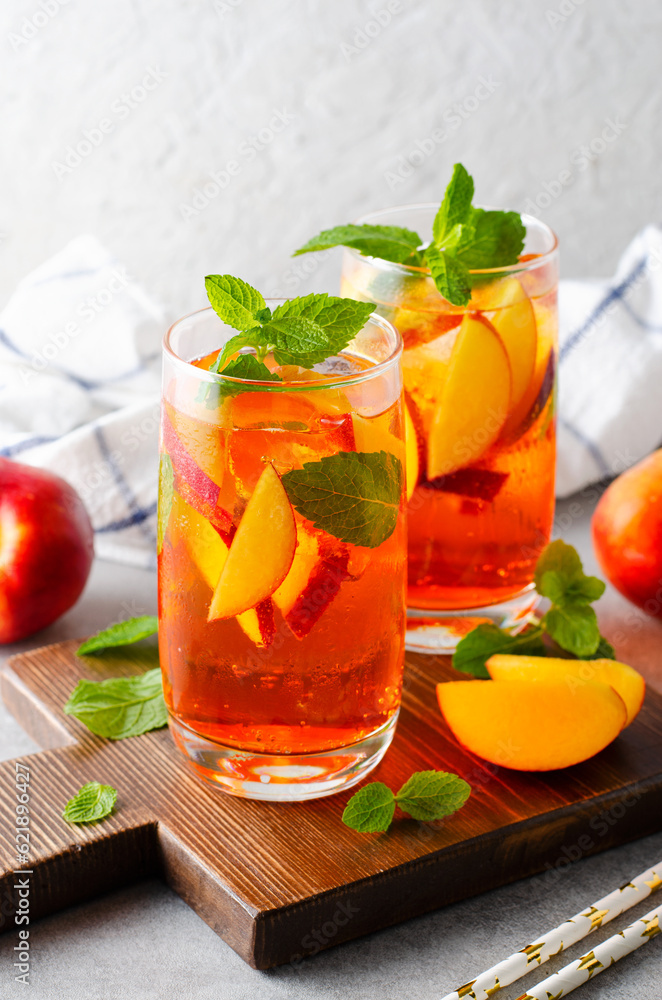 Fototapeta premium Peach Lemonade, Refreshing Drink, Cocktail, Iced Tea, Tasty Peach Cold Summer Drink on Bright Background