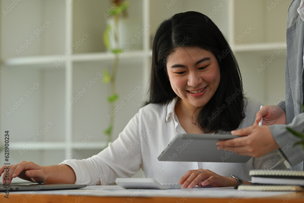 Portrait image of office worker and leader or coworker analyzing financial data on tablet together, business data analysis concept. Portrait image of office worker and leader or coworker analyzing financial data on tablet together, business data analysis concept.