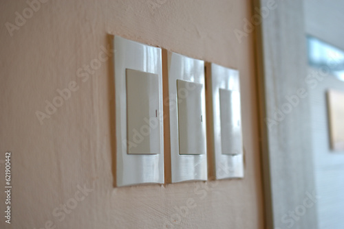 Household light switch on the wall. White plastic switch.