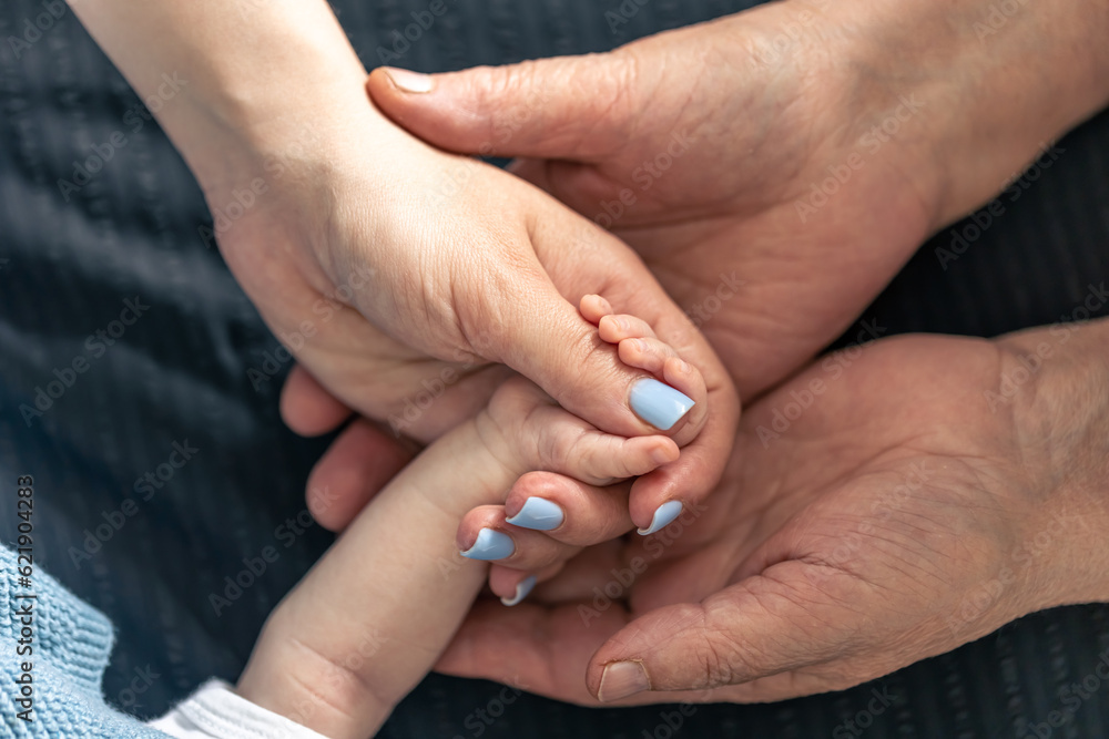 Close-up, hands of a baby, mother and grandmother. Close-up, hands of a baby, mother and grandmother.