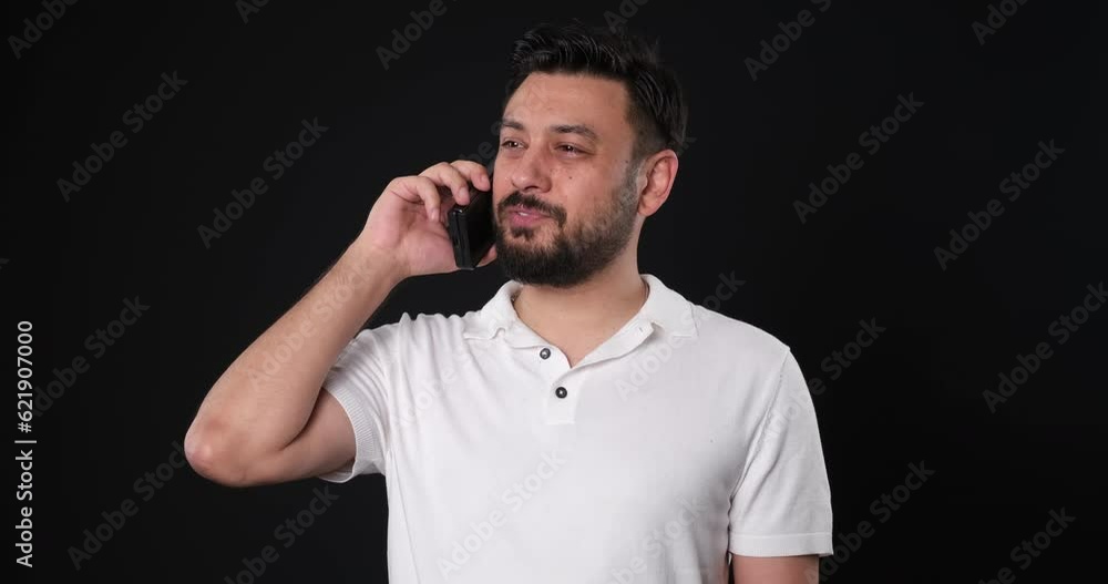 The when a middle-aged man in a studio setting, through close-up shots, looks at the camera and joyfully engages in a phone conversation The when a middle-aged man in a studio setting, through close-up shots, looks at the camera and joyfully engages in a phone conversation