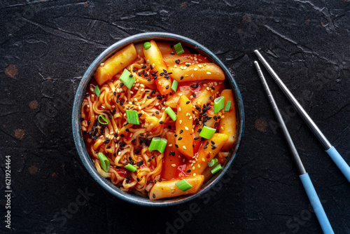 Rabokki, tteokbokki or topokki with ramen, Korean street food, spicy rice cakes in red pepper gochujang sauce, overhead flat lay shot photo