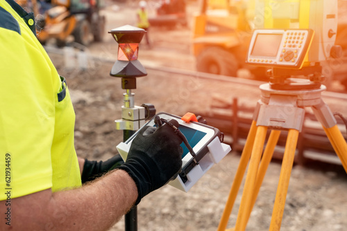 Billede på lærred Site engineer surveyor using rugged tablet controller computer to operate EDM to