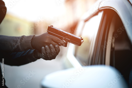Fotografi Thieves are using guns to rob a car, threatening a woman with car keys