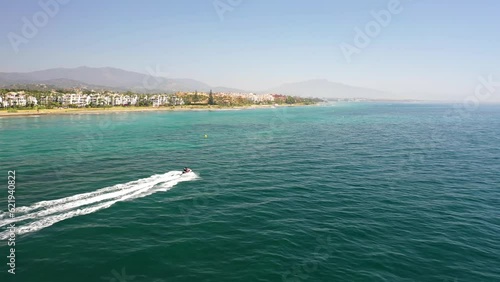 Aerial view of people with a jet ski along the coast off Estepona town, Malaga, Spain. photo