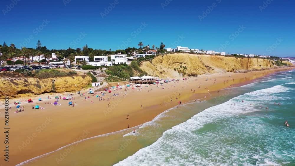 Aerial view of people relaxing at Playa La Fontanilla, a beach along the Atlantic Ocean coastline, Conil de la Frontera, Cadiz, Spain. Aerial view of people relaxing at Playa La Fontanilla, a beach along the Atlantic Ocean coastline, Conil de la Frontera, Cadiz, Spain.