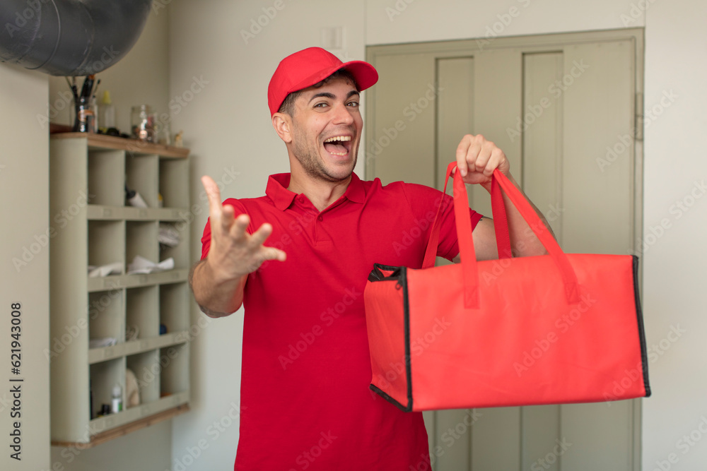 young handsome man smiling happily and offering or showing a concept. pizza delivery concept young handsome man smiling happily and offering or showing a concept. pizza delivery concept