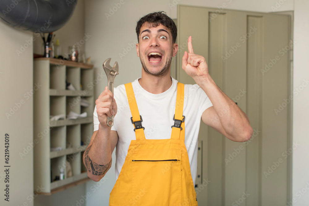 young handsome man feeling like a happy and excited genius after realizing an idea. handyman concept young handsome man feeling like a happy and excited genius after realizing an idea. handyman concept