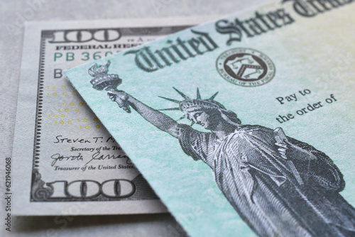 United States Government Treasury check with hundred dollar bill. 