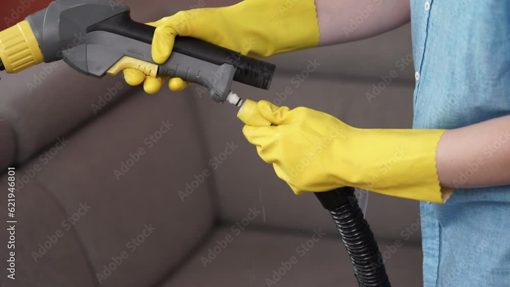 Dry cleaner's man employee removing dirt from furniture in flat