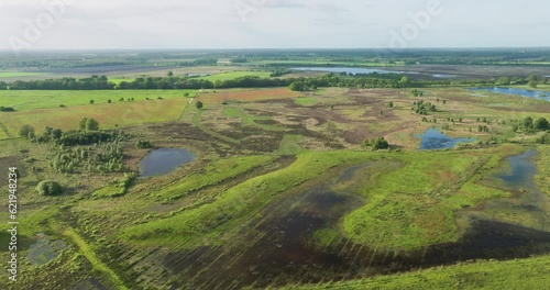 Aerial view of wet grassland, heather, trees and lakes in nature recovery area Scharreveld, flying sidewards, Westerbork, Drenthe, Netherlands. photo