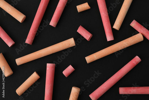 Multicolored pieces of chalk on a black background