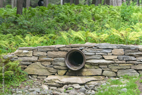 Rock wall and drainage pipe new england forest photo