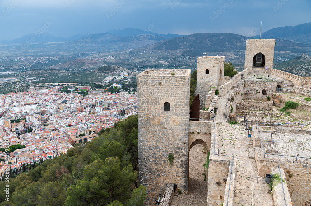 Vista de las torres y muralla del castillo de Santa Catalina sobre una vista aerea de la ciudad de Jaen, Andalucia, España. 