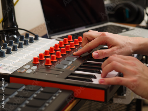 Sound engineer in a recording studio close-up. MIDI keyboard, remote. Musical equipment, instruments. Professional activity, hobby.
