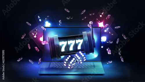Laptop, slot machine, neon playing cards, dice and poker chips on dark background