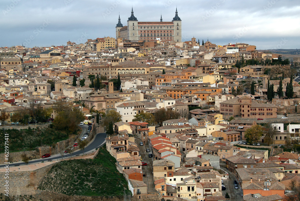 Panoramic view of the historic part of the city with the Alcazar de Toledo military museum building on the hill against a stormy sky in the city of Toledo, near Madrid, Spain