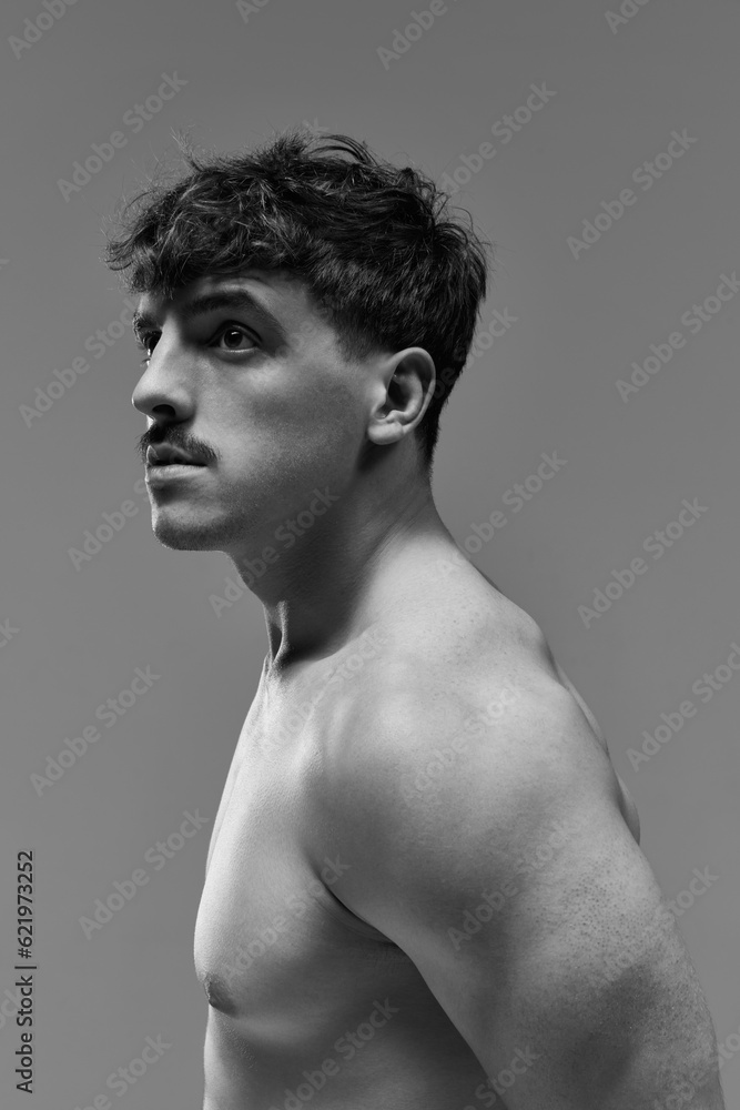 Fototapeta premium Portrait of young handsome man posing shirtless with serious facial expression. Muscular body. Black and white aesthetics. Concept of man's beauty, sportive and healthy lifestyle, athletic body