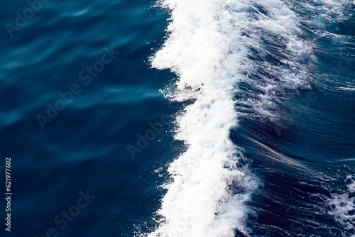 Ocean close up. Background of blue water with white foam.