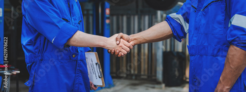 Auto mechanic handshake showing success collaboration of mechanics Check and maintain the engine for customers.