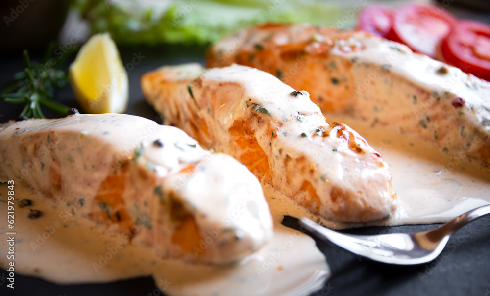 Cooked salmon fish with cream sauce in frying pan