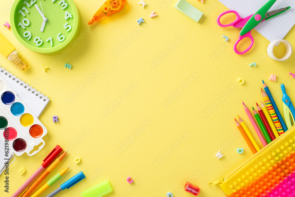 Explore magic of early education with this top-down perspective: delightful collection of colorful school supplies on isolated yellow backdrop, offering empty circle for text or promotional content Explore magic of early education with this top-down perspective: delightful collection of colorful school supplies on isolated yellow backdrop, offering empty circle for text or promotional content