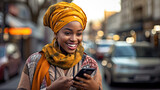 African woman reads good news from a smartphone screen while standing on the street.