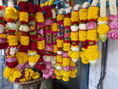 Flowers in Hinduism. Symbol of creation and rebirth. Colorful flowers on market stall. Hindu traditional flower garland. Varamala, Jayamala. Mala Garlands for sale. Close-up view. Bright colors. India